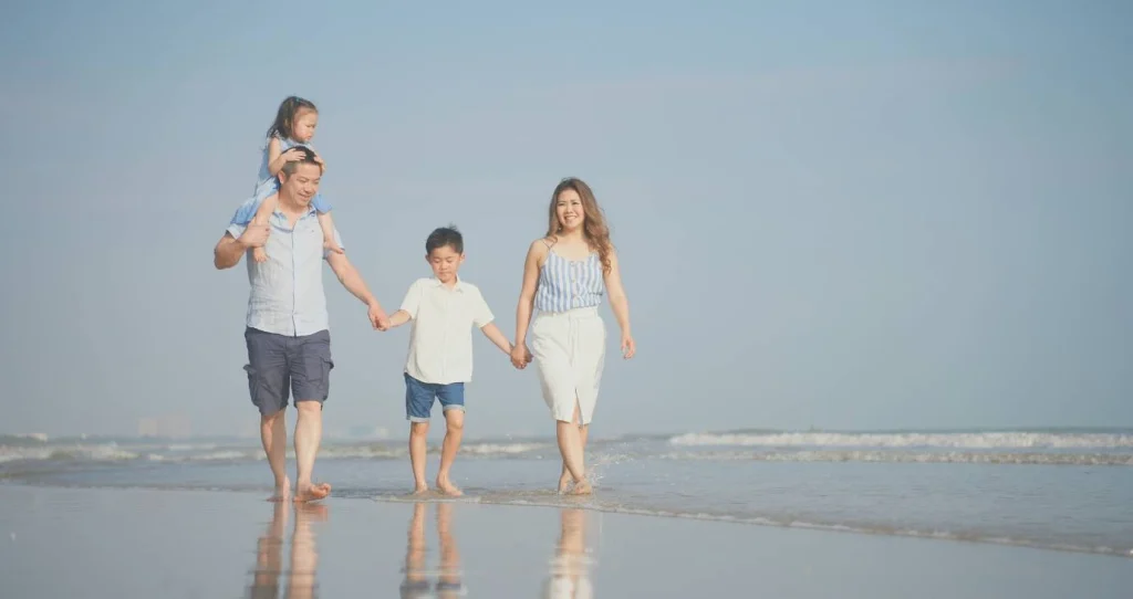 Family of mother, father and two children on beach